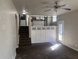 Interior space with ceiling fan and dark carpet