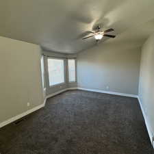 Carpeted empty room featuring a textured ceiling and ceiling fan