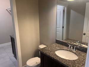 Bathroom with vanity, tile patterned floors, and toilet