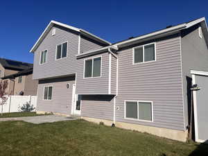 Rear view of property with a lawn and a patio area