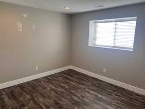 Unfurnished room with dark hardwood / wood-style flooring and a textured ceiling