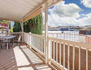 Deck featuring outdoor dining space with retractable sunshades