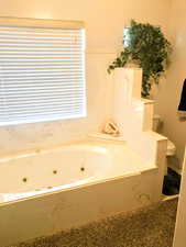 jetted tub, toilet, sink in full bathroom on main floor