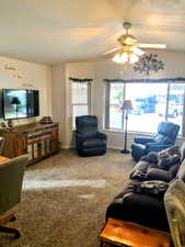 Living room with ceiling fan and carpet flooring, vaulted cealings and very open with big windows