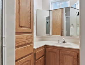 Bathroom in bedroom 1 with walk in shower, toilet, lighted vanity and lots of storage.