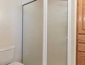 Bathroom in bedroom 1 with walk in shower, toilet, lighted vanity and lots of storage.