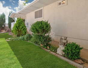 View of yard with beautiful landscaping and walkway along house from front to back porches