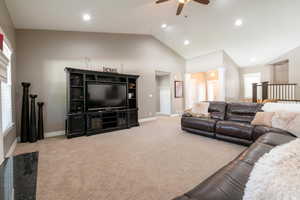 Carpeted living room featuring ceiling fan, a healthy amount of sunlight, and high vaulted ceiling