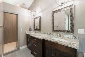 Bathroom with a shower, tile patterned flooring, and vanity