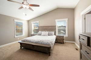 Bedroom featuring lofted ceiling, light carpet, and ceiling fan