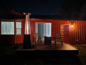 Back house at twilight with a wooden deck