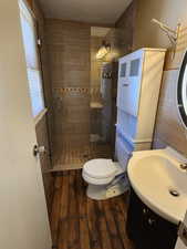 Bathroom with a wealth of natural light, vanity, hardwood / wood-style flooring, and toilet