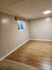 Spare room featuring wood-type flooring and a textured ceiling