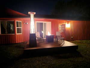 Back house at twilight with a wooden deck