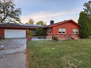 Ranch-style house with a garage, a lawn, and central AC