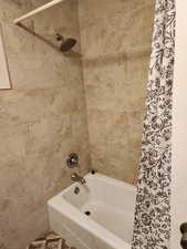 Bathroom with shower / bath combination with curtain