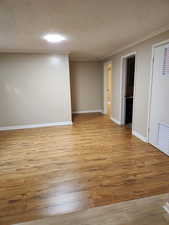 Spare room with light wood-type flooring and ornamental molding