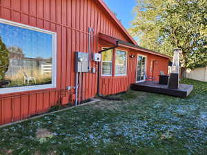 View of property exterior with a lawn and a deck