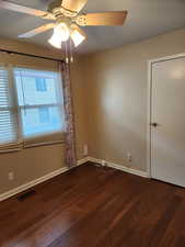 Spare room featuring ceiling fan and dark hardwood / wood-style flooring