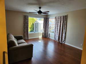 Living area featuring dark hardwood / wood-style flooring and ceiling fan