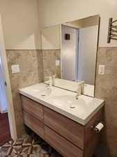 Bathroom with vanity and tile walls