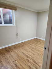 Unfurnished room featuring light hardwood / wood-style floors and crown molding