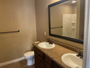 Bathroom featuring toilet, vanity, and tile patterned floors now that unit is vacant for new owners