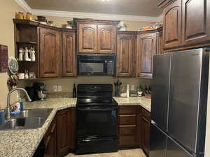 Kitchen featuring dark brown cabinetry, sink, black appliances, and ornamental molding