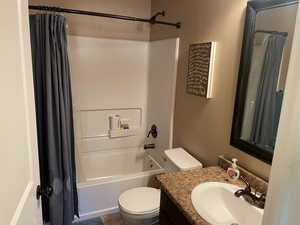 Full bathroom with shower / bath combo, vanity, and toilet