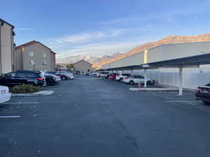 View of parking with a mountain view and a carport