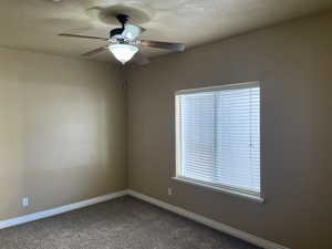 Spare room featuring ceiling fan and carpet floors now that unit is vacant for new owners