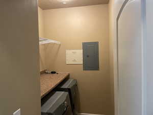 Washroom featuring a textured ceiling and electric panel