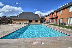 View of pool featuring a patio area by clubhouse