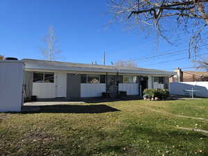 View of front of home with central air condition unit and a front yard