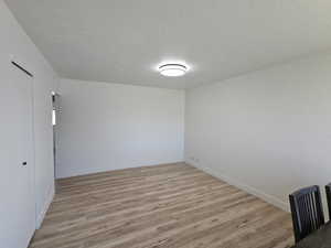 Spare room with a textured ceiling and light wood-type flooring