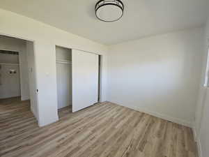 Unfurnished bedroom with light hardwood / wood-style flooring and a closet