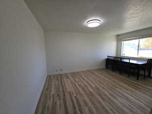 Unfurnished room with dark hardwood / wood-style flooring and a textured ceiling