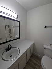 Bathroom with wood-type flooring, vanity, and toilet