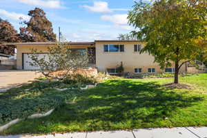 View of front facade featuring a front lawn and a garage