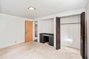 Unfurnished bedroom featuring light colored carpet and a closet