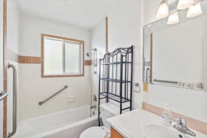 Full bathroom featuring vanity, toilet, and tiled shower / bath