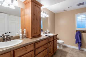 Bathroom featuring toilet, vanity, and tile patterned floors