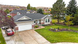 View of front of property featuring front lawn, garage, and mountain view