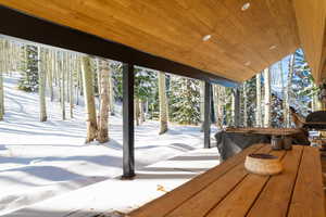 Snow covered deck featuring a patio area