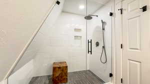 Bathroom featuring tile patterned floors and a shower with shower door