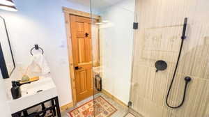 Bathroom featuring sink and tiled shower