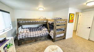 Carpeted bedroom featuring a baseboard heating unit