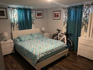 Bedroom featuring dark wood-type flooring and a textured ceiling