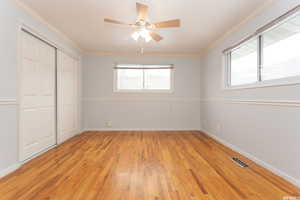 Unfurnished bedroom with a closet, ornamental molding, and light hardwood / wood-style flooring