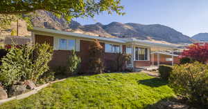 View of front of property featuring a front lawn and a mountain view